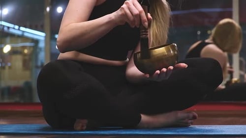 Woman Using Singing Bowl During Meditation at Night