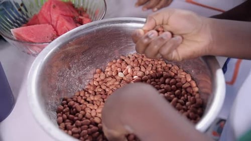 Removing stones or bad peanuts or groundnuts in preparation for frying or roasting them