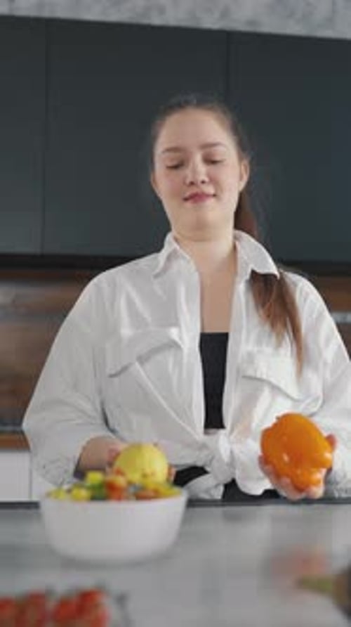 Woman Juggling Fruit and Vegetables in Kitchen