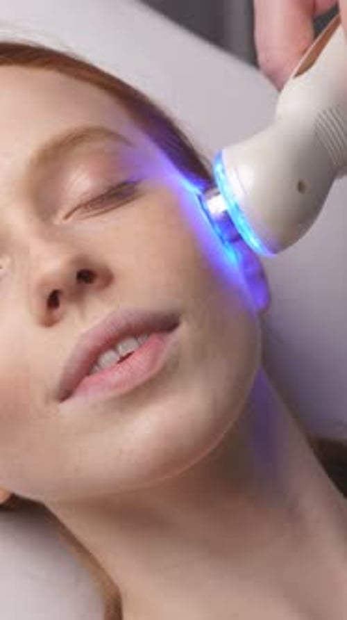 Red Haired Woman Receiving Light Therapy Facial