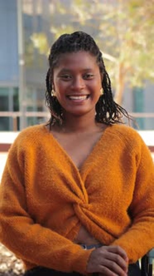 Joyeuse jeune femme souriant avec confiance tout en profitant d'un moment de joie et de connexion avec des amis