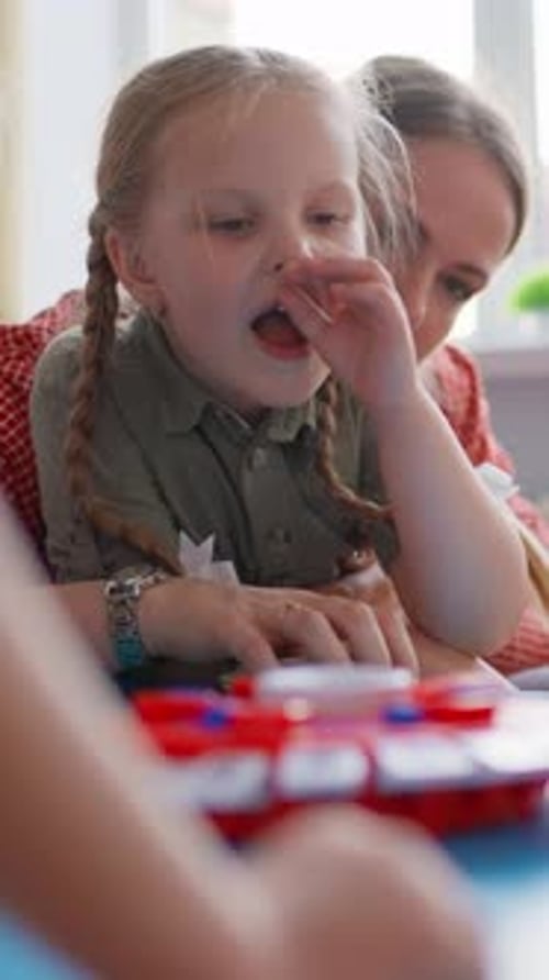 Children Engaged in a Focused and Interactive Educational Activity Playing with a Red and White