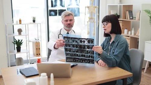 Doctor Explains Brain Scan to Woman in Office