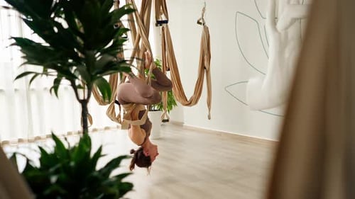 Woman Doing Aerial Yoga in Fitness Studio