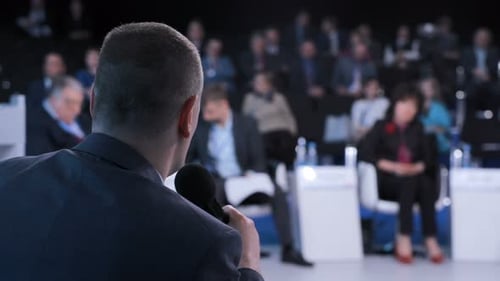 Confident businessman explaining strategy at seminar in modern conference hall