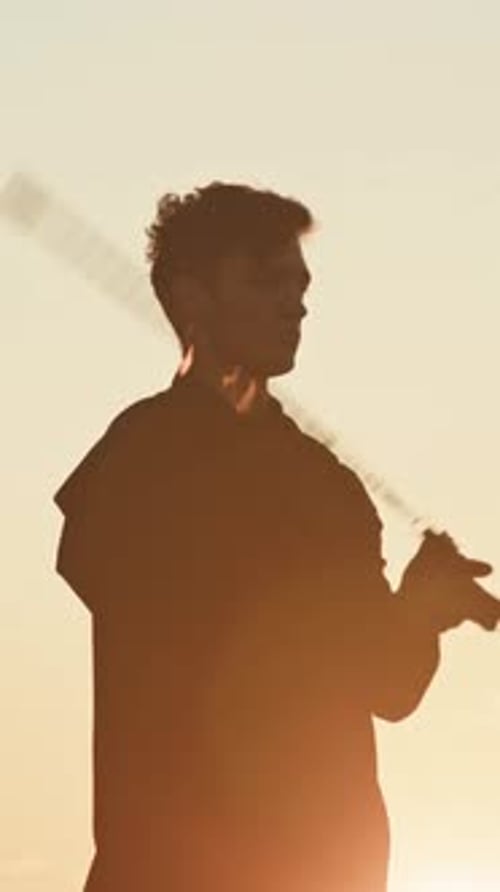 Boy Juggling with Fire Chains at Sunset