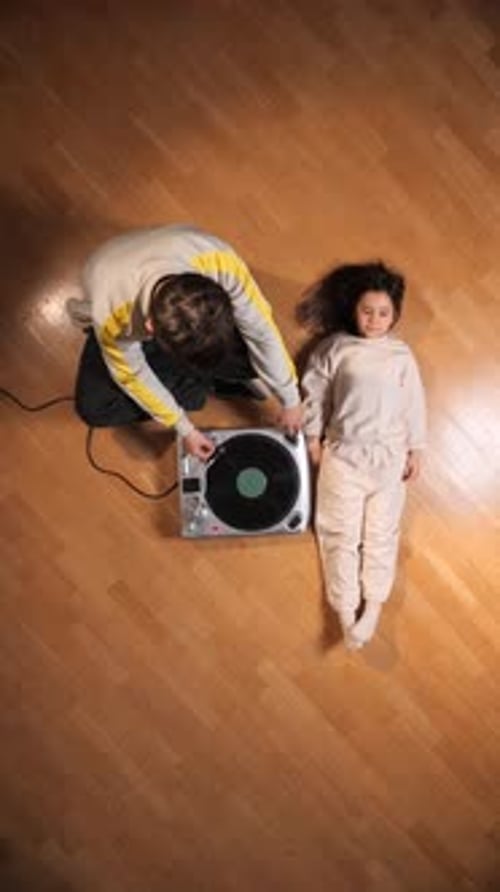 Child Lying Beside Adult Playing Vinyl Record Player