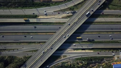 Aerial shot of car traffic driving along busy city urban highway interchange zoom out