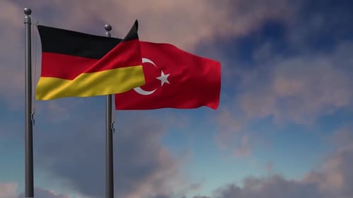 German And Turkish Flags Waving With Cloudy Sky Background