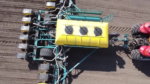 Tractor with yellow seeder working on the field in Ukraine OA Lexa