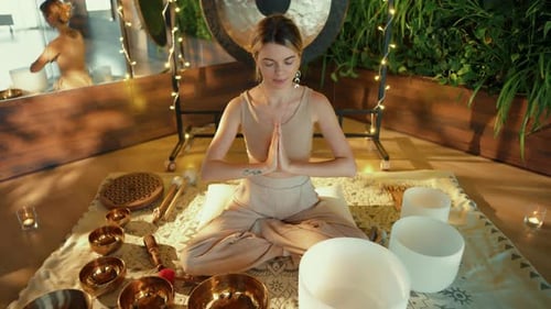 Woman Meditating with Singing Bowls and Gong