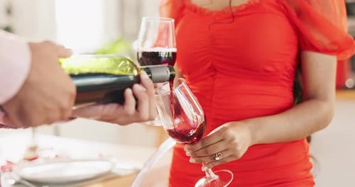 Couple, hands and pour red wine for celebration of love, romance and valentines day on anniversary