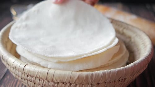 Slow Motion of Hand Pick Homemade Rice Chapati in a Bowl