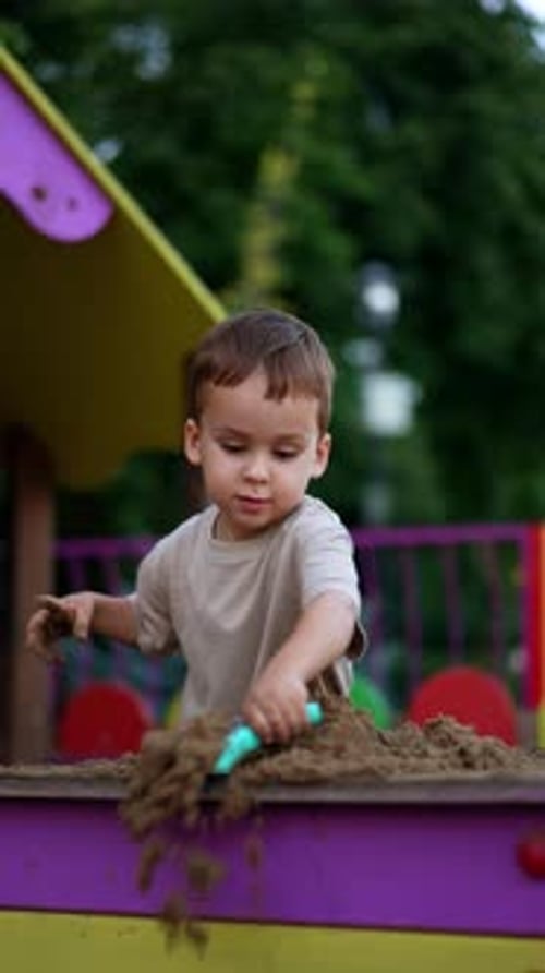 Little Boy Playing Happily in a Sandbox