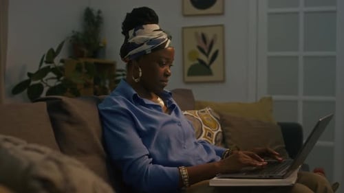 Woman Working on Laptop on Couch at Night