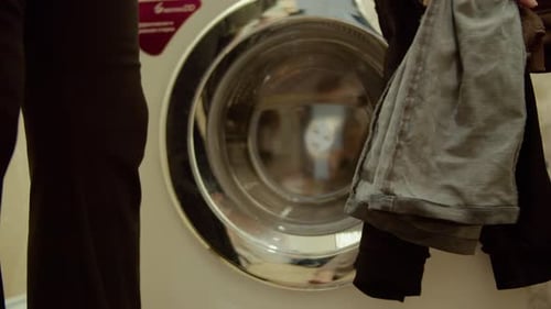 Clothes Being Loaded Into Washing Machine