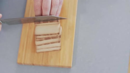 Slicing Tofu on a Wooden Cutting Board