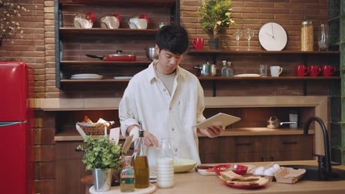 Young Adult Follows Recipe on Tablet in Kitchen