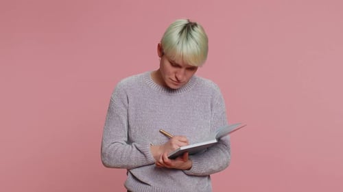 Young Adult Writes in Notebook