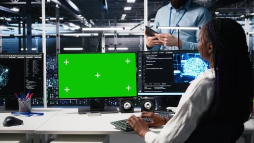 Programmiererin spricht mit Manager im KI-Rechenzentrum mithilfe eines Mockup-PCs