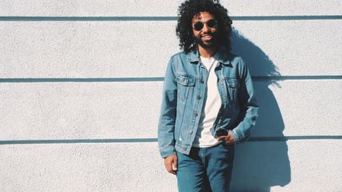 Young Adult Leaning Against Urban White Wall