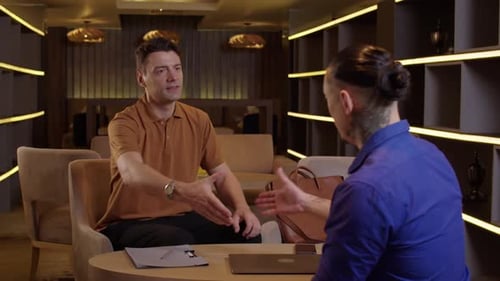 Businessmen Shaking Hands at a Table Inside