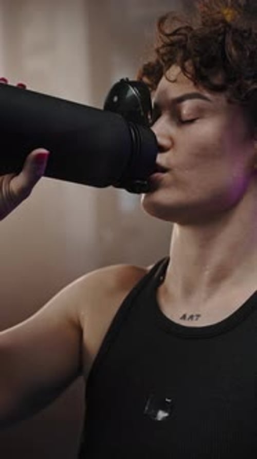 Young Adult Woman Drinking Water in Gym