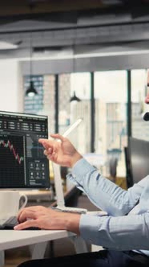 Vertical Video Investment Consultant Talking in Headset Mic Reviewing Client Portfolio