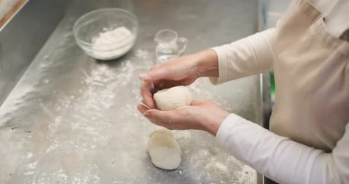 4k video footage of an unrecognizable baker shaping dough in a bakery