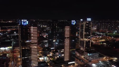 Aerial downward shot of illuminated residential buildings in city at night - Drone shot of city at n