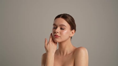 Woman Applies Skincare, Posing in Studio