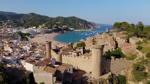 Ascending drone shot of Spanish town castle and beach