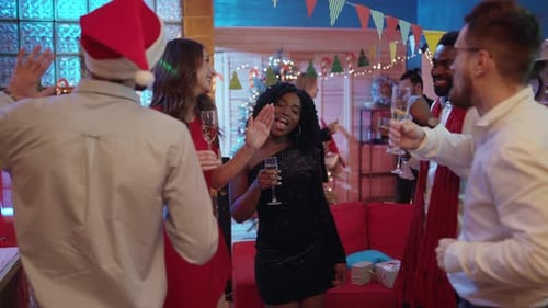 Friends Celebrating Christmas Holiday with Drinks and Dancing