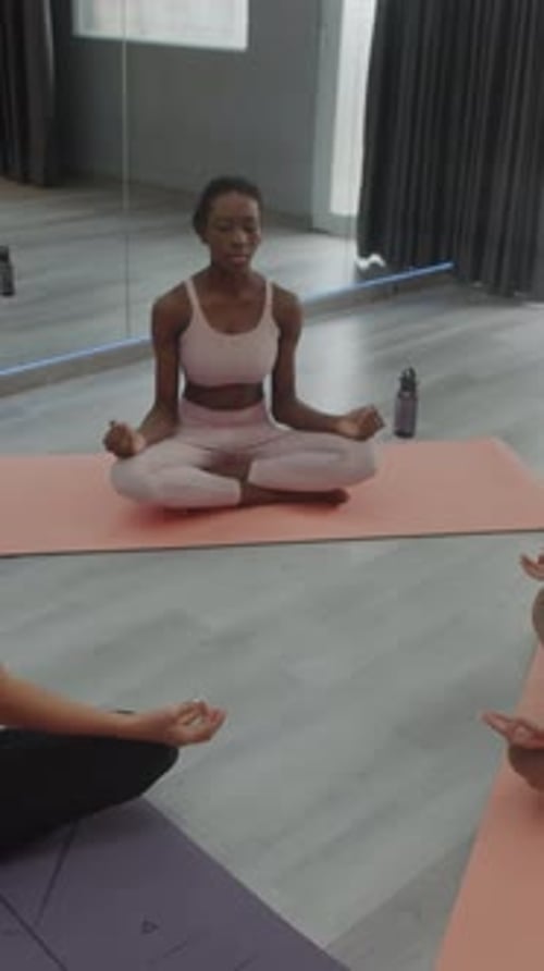 Woman Practicing Yoga Meditating in Studio