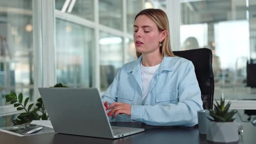 Serene Woman Sitting in Office Chair and Gazing Fixed on Screen of Laptop