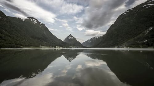 Spiegelung von Wolken und Bergen im nebligen Tal im Zeitraffer