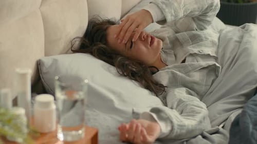 Woman Suffering from Headache Lying in Bed