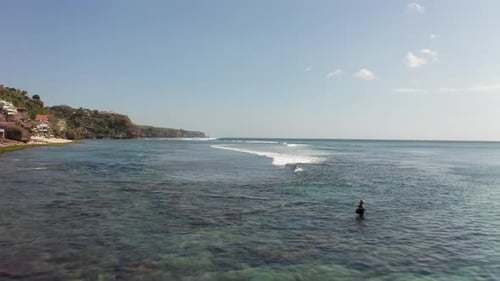 Low flyover fisherman in middle of ocean next to hidden beach in Bali Indonesia. Dreamland surfers b