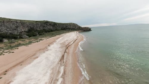 A long empty beach with the sea