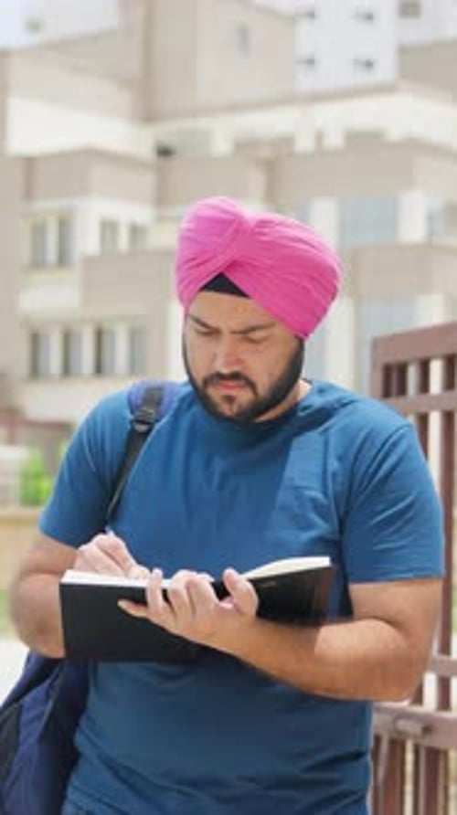Vidéo verticale d'un Indien sikh écrivant dans un carnet