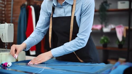 Dressmaker Marking Fabric with Chalk in Bright Workplace