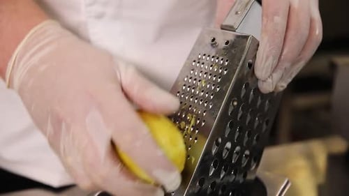 Chef Grating Lemon Zest with Gloves Close Up