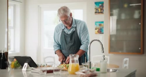 Senior Man Chopping Vegetables in Bright Kitchen