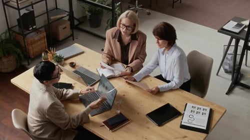 Three Professional Middle-Aged Women Having Business Discussion in Office