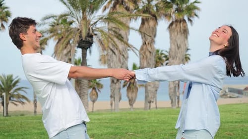 Loving Couple Holding Hands and Laughing on Beach
