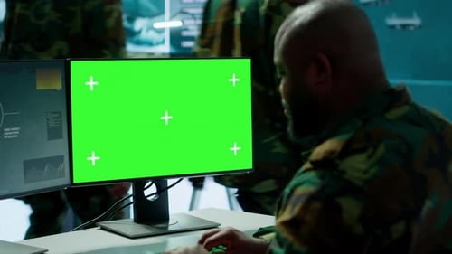 Military Personnel Working at Computers with Green Screen