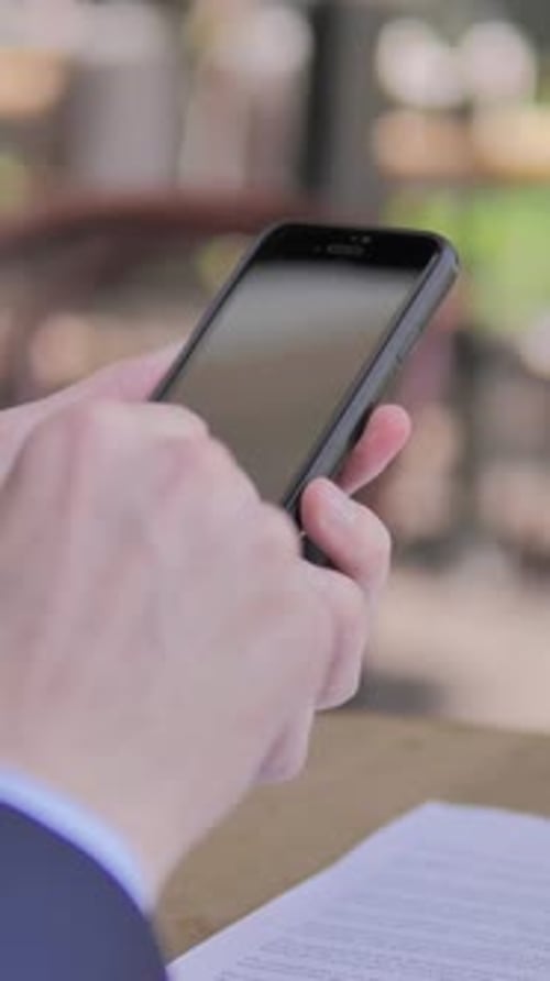 Browsing on Smartphone in Outdoor Cafe, Vertical Video