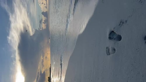 Feet marked in the white sand on the seashore