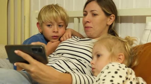 Woman and Children Watch Smartphone in Bed