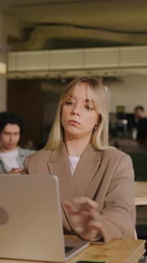 Focused Professional Woman Working on Laptop at Wooden Desk in Modern Cozy Office with Warm Lighting